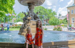 kids posing for a picture beside the fountain