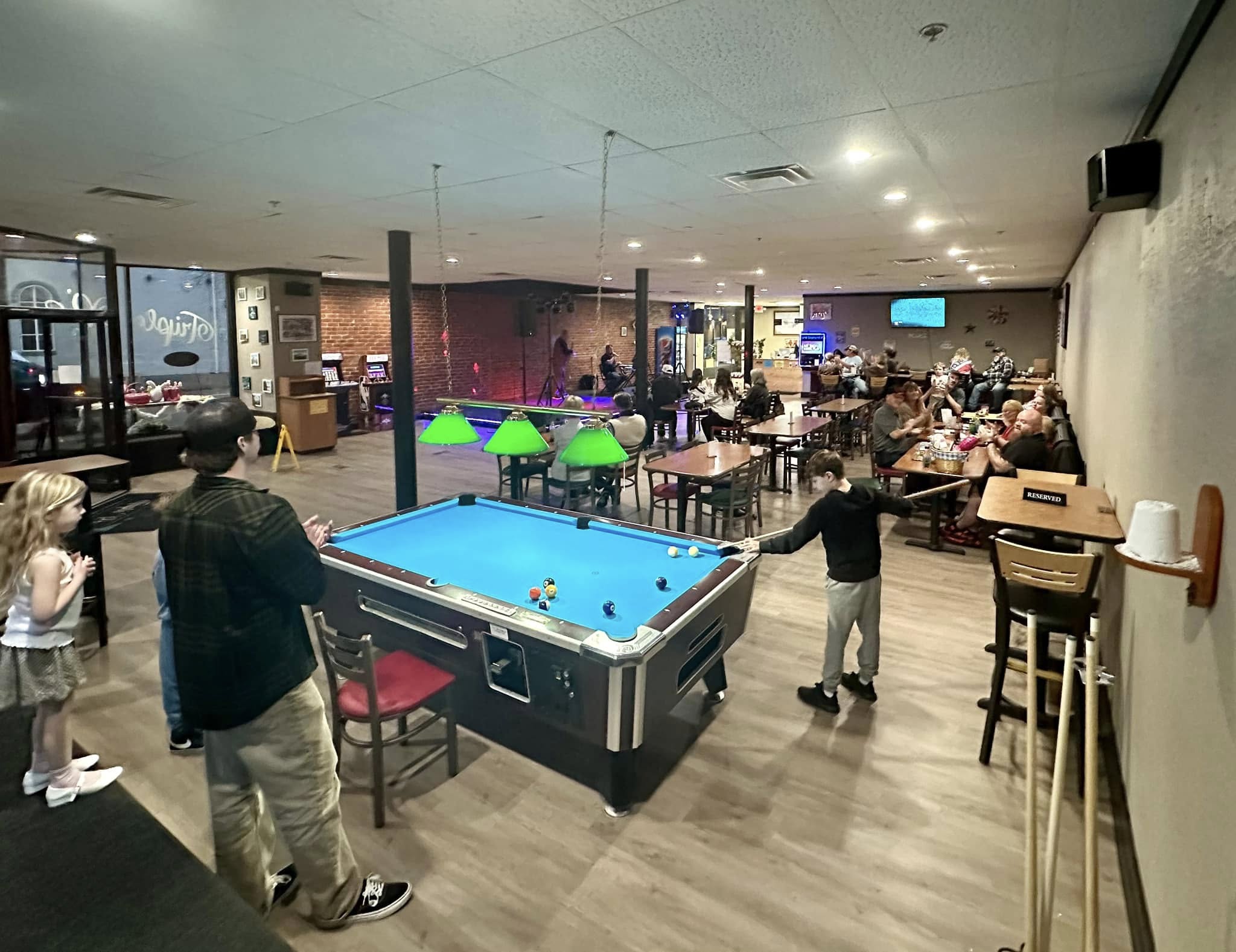 people gathered at a restaurant playing games and enjoying karaoke