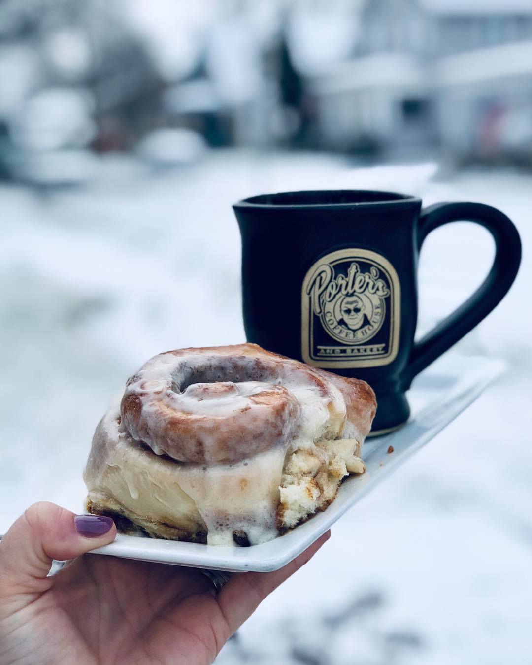 coffee and cinnamon roll outside in the snow