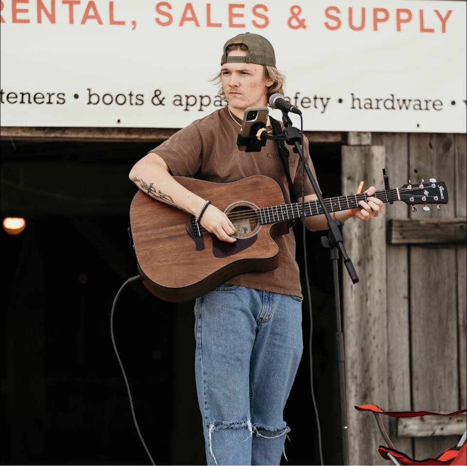 Photo of singer Kade Dennison playing the guitar