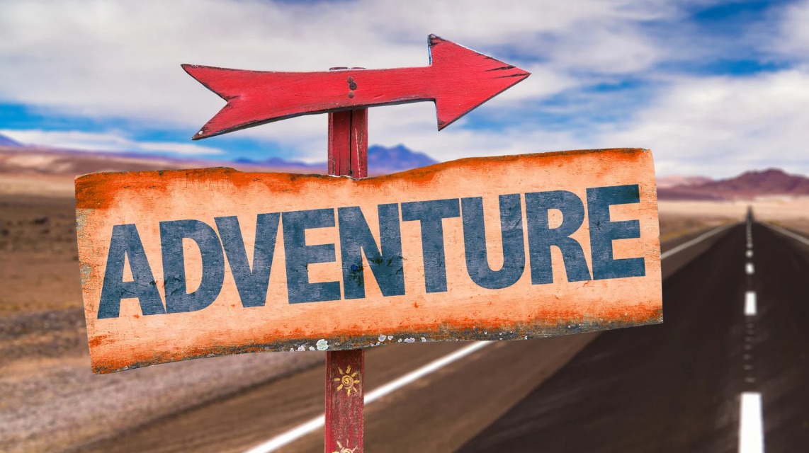 old sign saying adventure with a red arrow pointing to a road